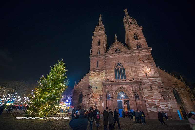 imagen nocturna de la catedral de Basilea, con un árbol gigante.