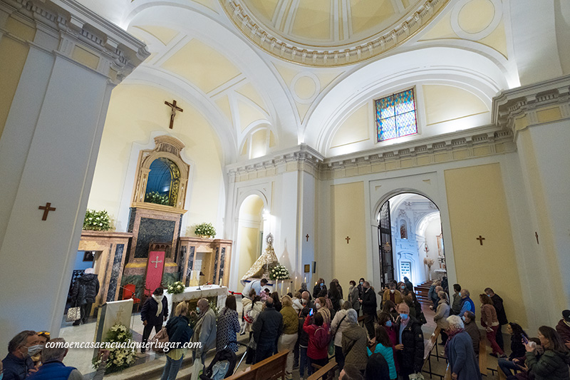 Imagen, interior del santuario con gente rezando, donde se ve el altar. fiestas Fuencarral