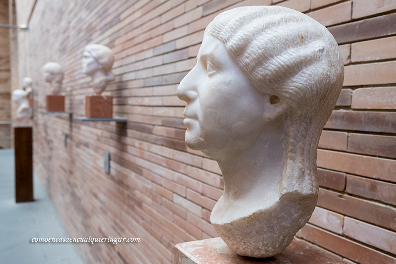 Foto un busto romano en primer plano a la derecha y de fondo más bustos Museo Nacional de Arte Romano Mérida