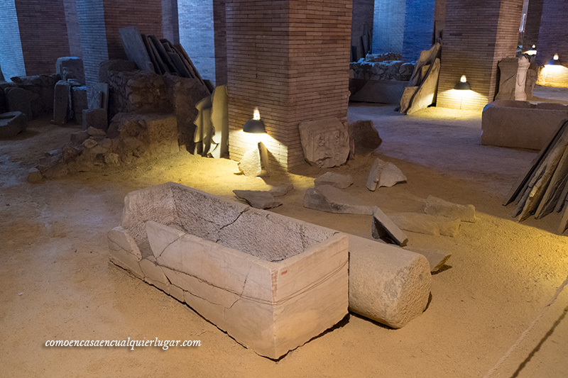 imagen Cripta subterránea, con una columna en el suelo y detrás una caja de piedra en forma de ataúd, al fondo más restos arqueológicos.  